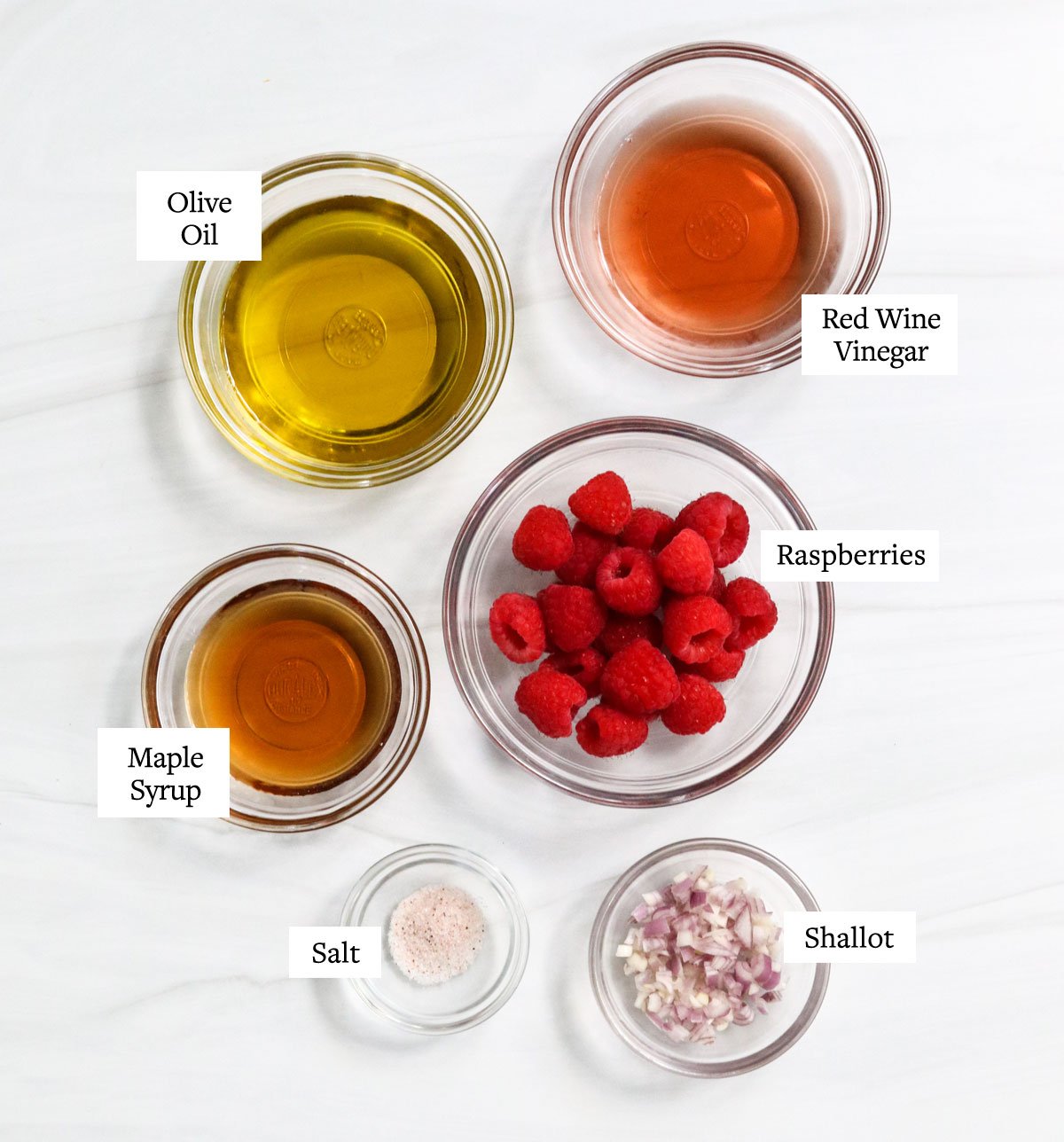 raspberry vinaigrette ingredients labeled in glass bowls.