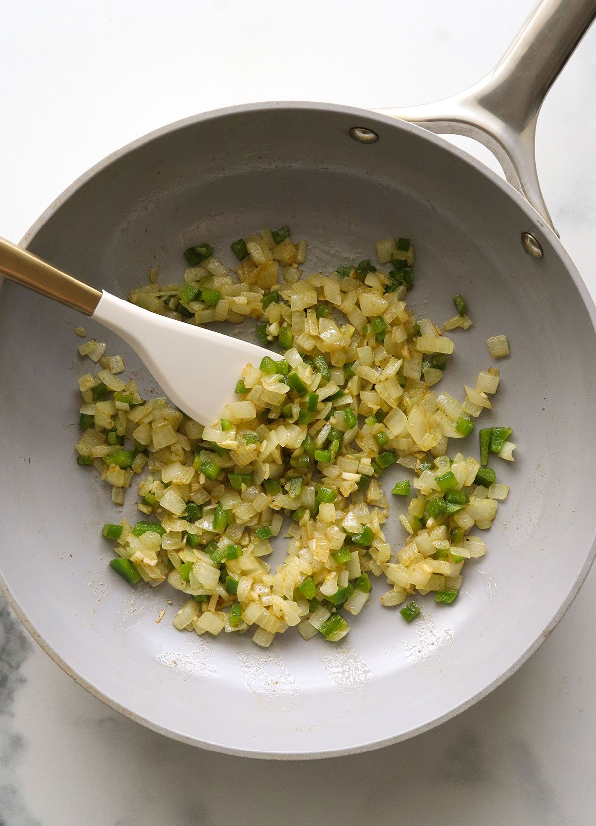 sauteed onion garlic and jalapeno in a gray skillet.