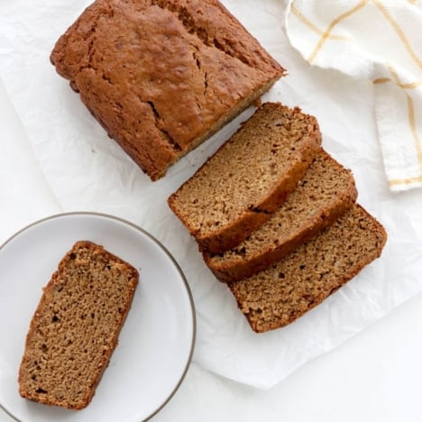 overhead vegan banana bread sliced on a white surface