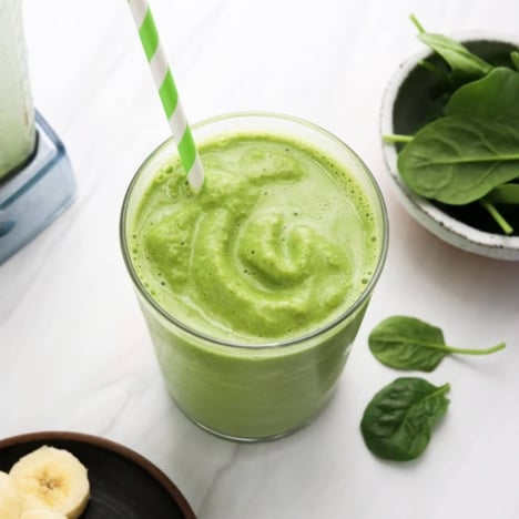 spinach smoothie with green striped straw