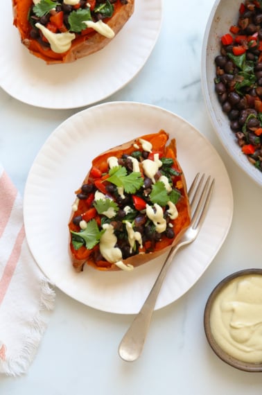 sweet potato stuffed with black beans and topped with cashew cheese sauce.