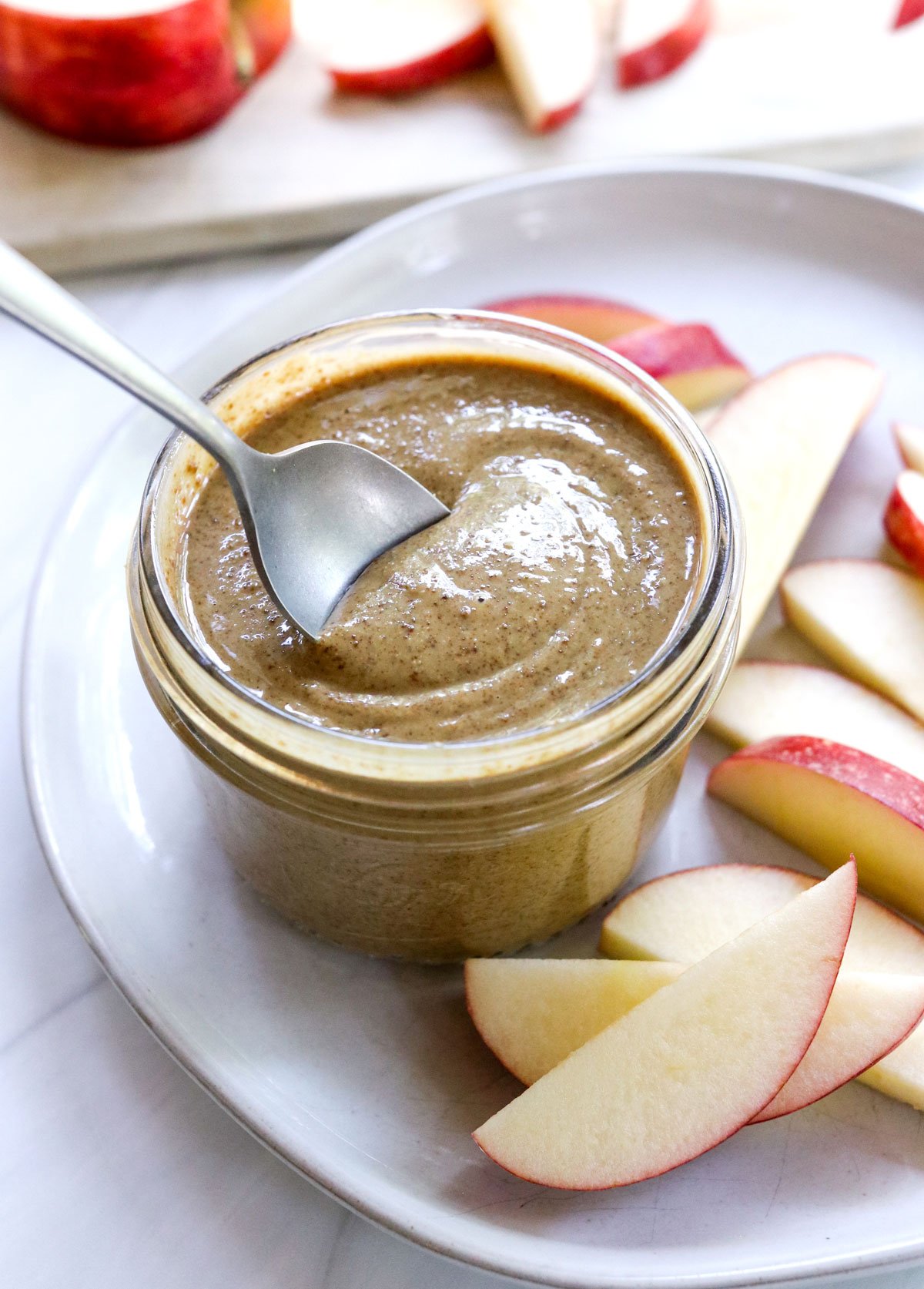 sunflower butter in a jar with a spoon lifting it up.