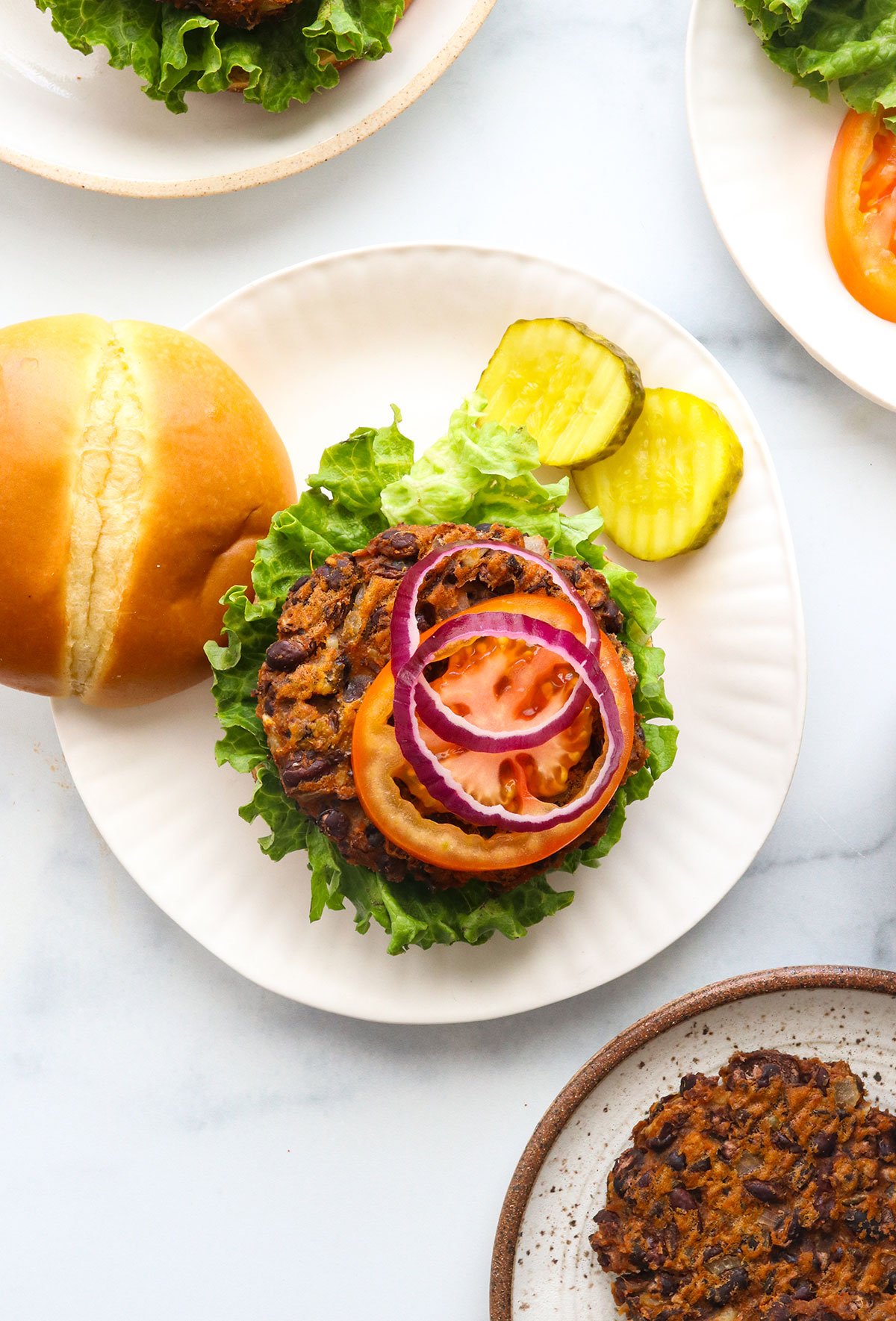 sweet potato black bean burger on a bun with toppings.