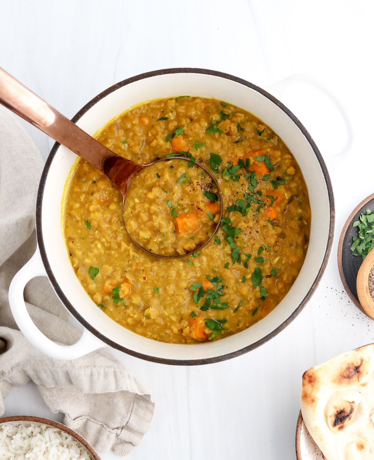 sweet potato curry with ladle in a white pot