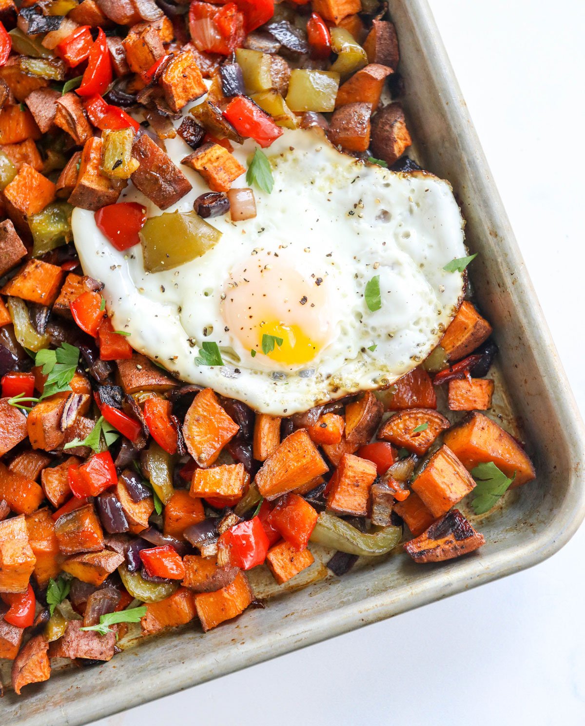 sweet potato hash on pan with eggs