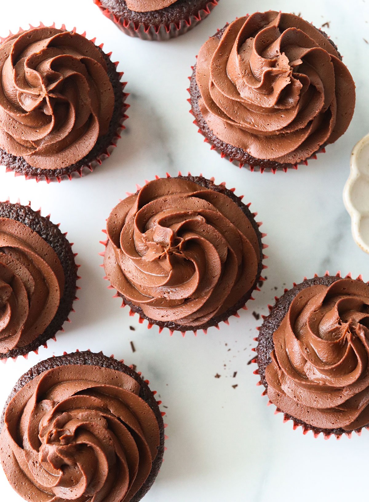 vegan ganache piped over chocolate cupcakes from overhead angle.