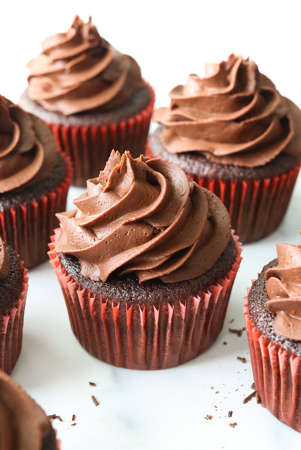 vegan ganache piped generously on chocolate cupcakes.