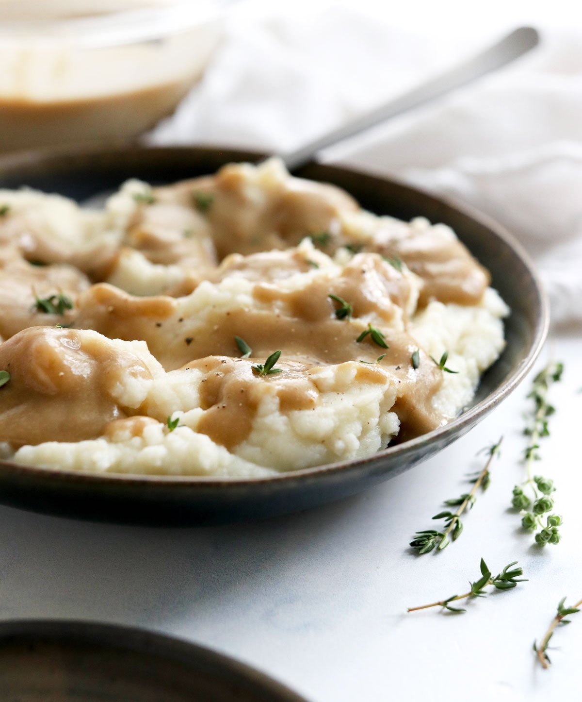 vegan gravy on mashed potatoes with fresh herbs