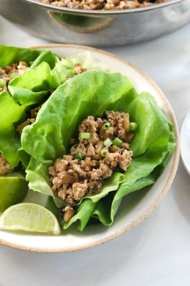 vegetarian lettuce wraps served with lime wedges.