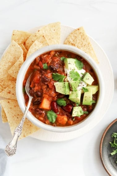 veggie chili in bowl with avocado on top